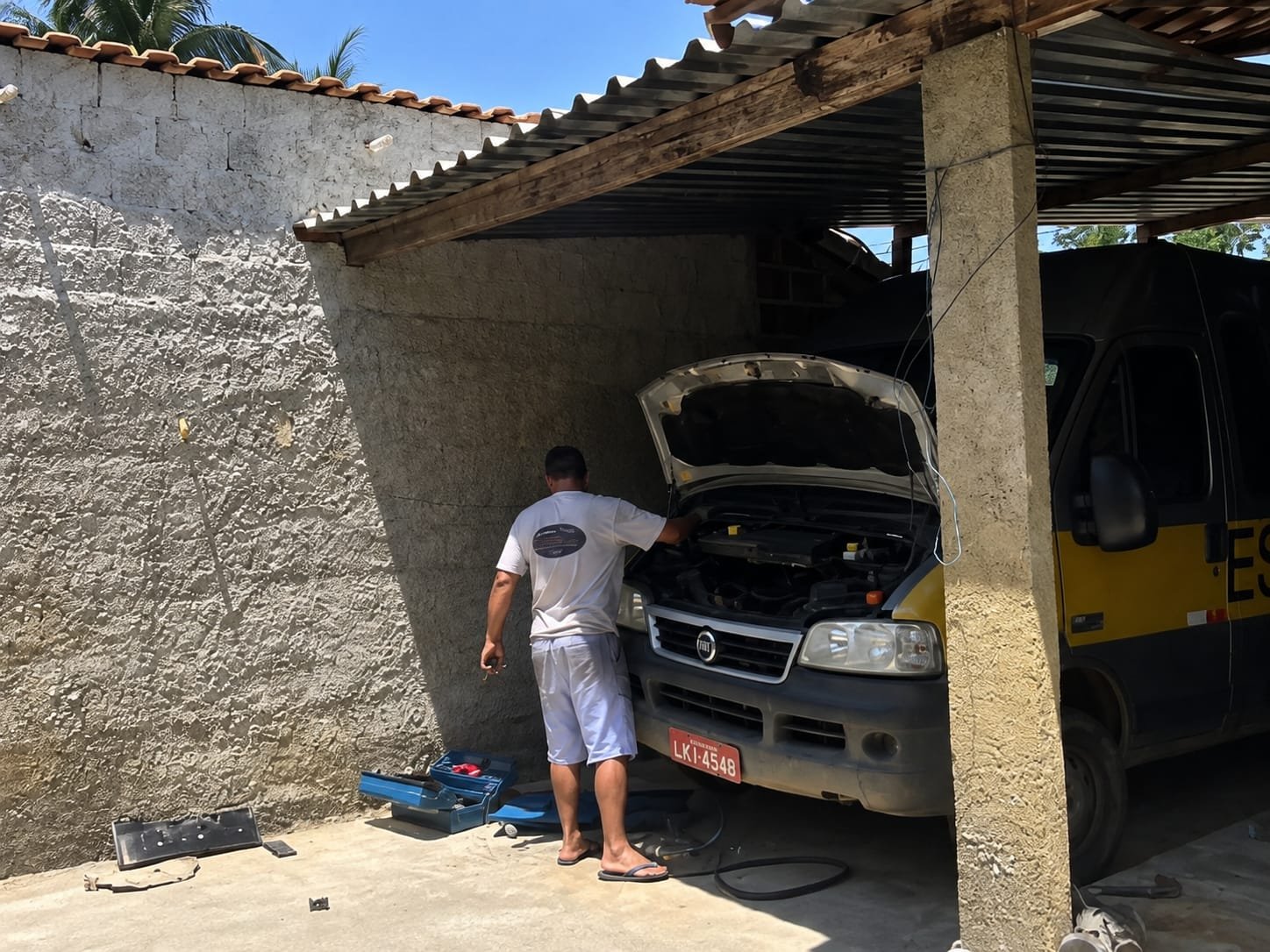 Estrutura simples do início da Peçauto, com uma van Fiat em manutenção