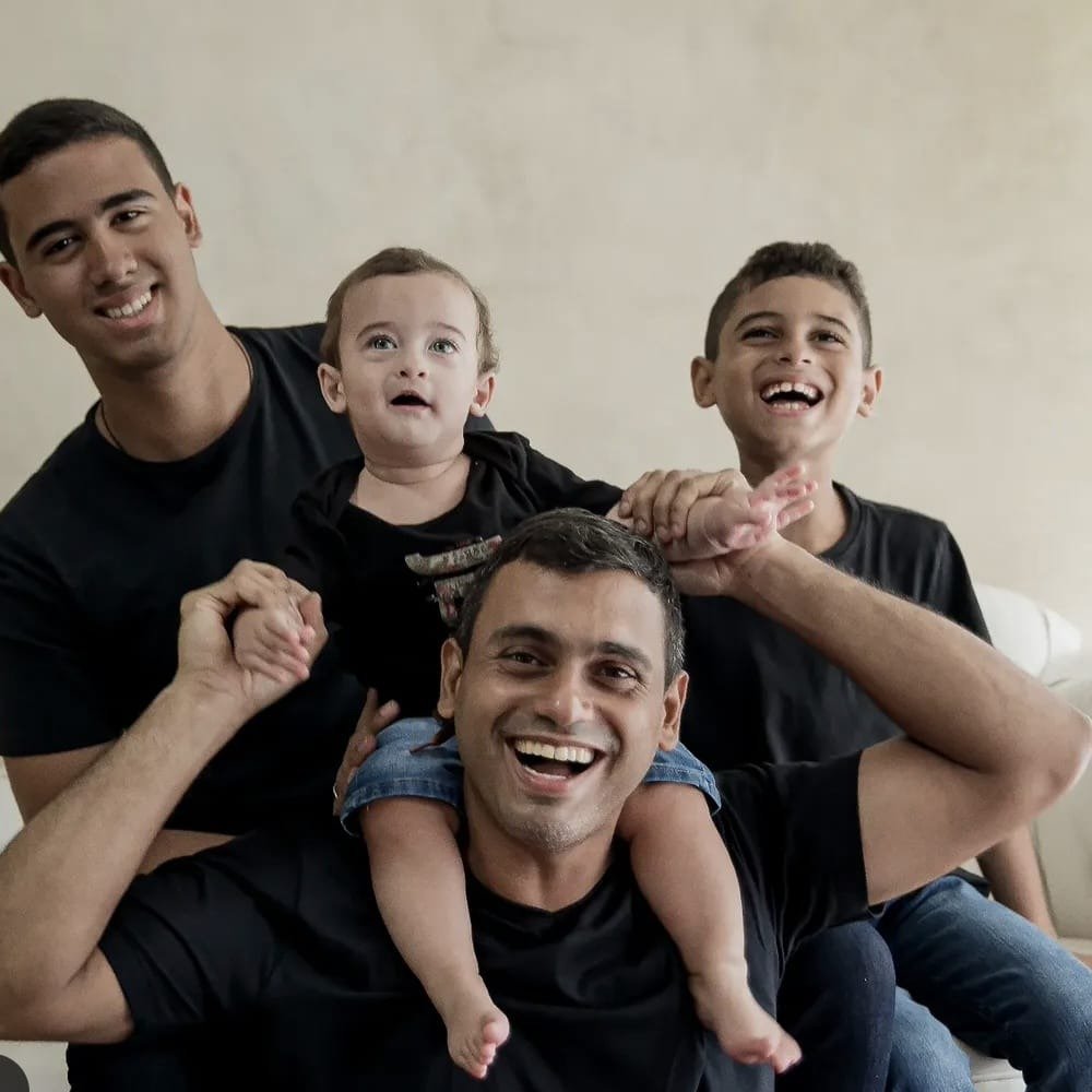 Peterson Frias sorrindo ao lado dos filhos Arthur, Pedro e Afonso